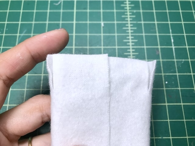 batting encased by white flannel fabric, and fabric is snipped