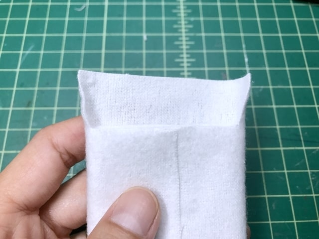 batting encased by white flannel fabric, and excess fabric is cut away