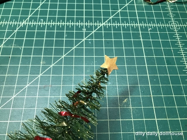 mini golden star as a topper to mini Christmas tree