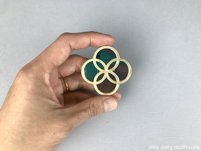 miniature mirror attached to the painted frame