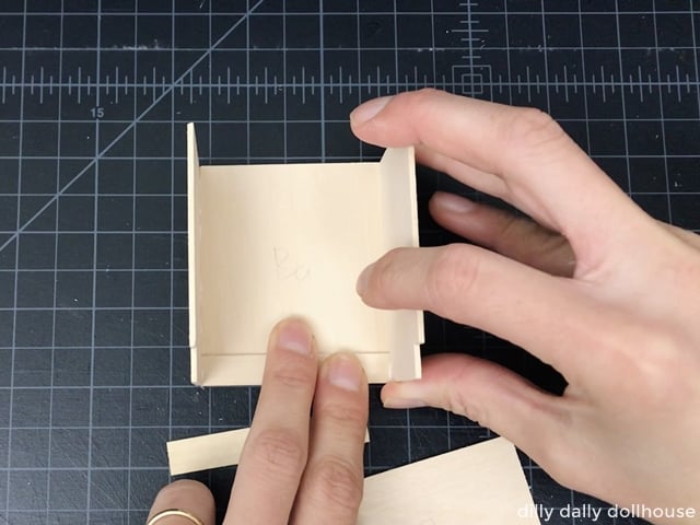 attaching the sides of the dollhouse kitchen cabinet.
